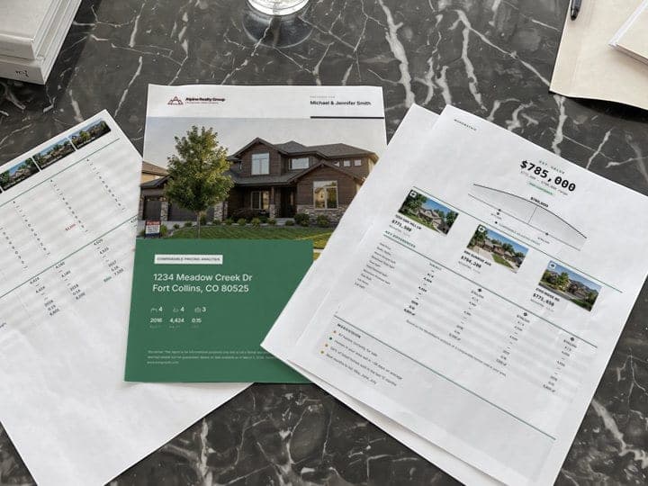 Printed pages of a Kompmodo report for 1234 Meadow Creek Dr on a marble coffee table: the cover, the comparables grid and the $785,000 recommendation.